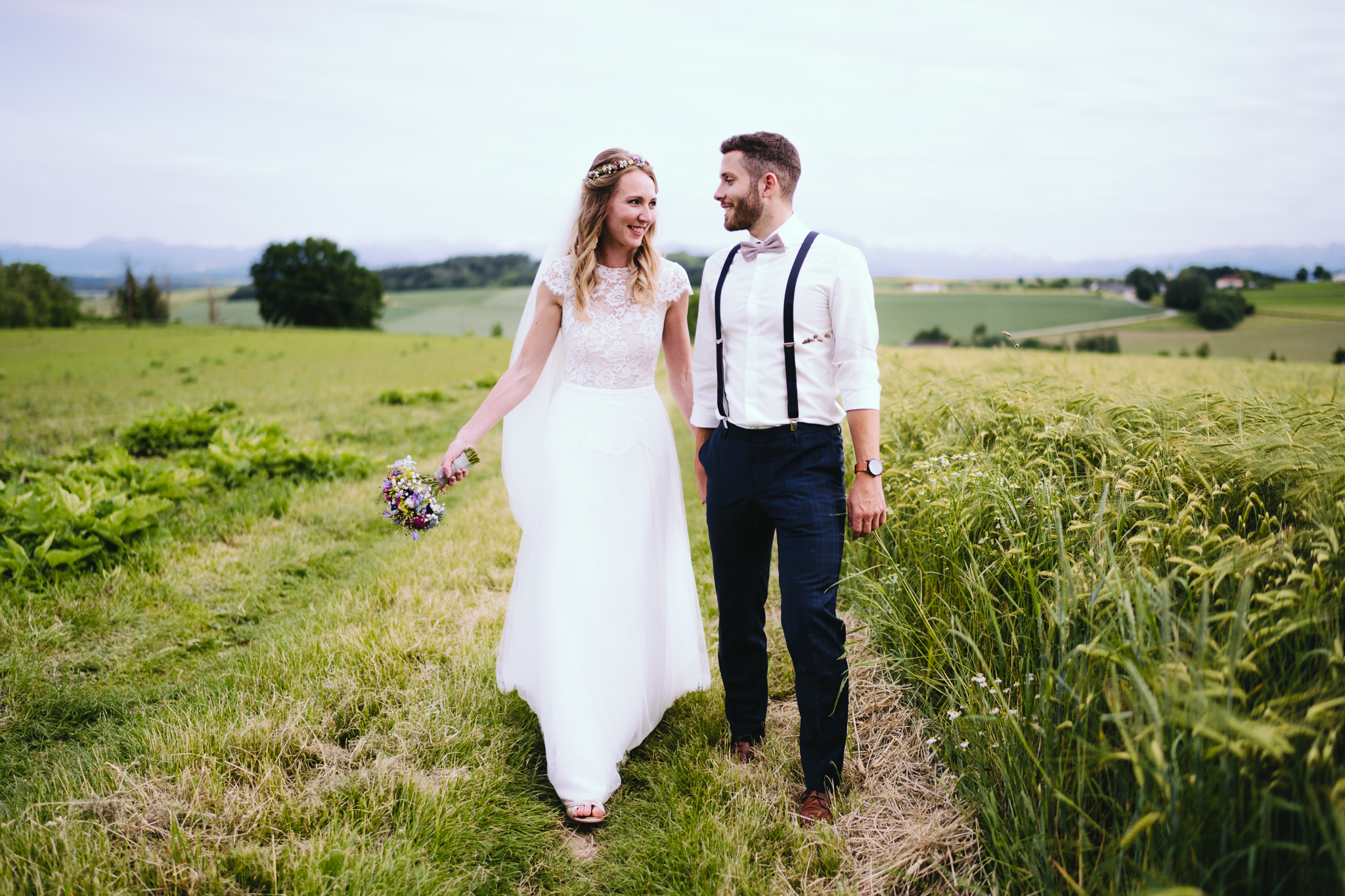 Hochzeitspaar schlendert über Feldweg