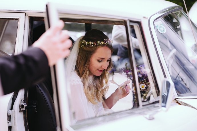 Braut steigt ins Auto ein Weil i di moog fotografie