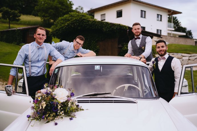 Bräutigam mit Freunden vor Auto